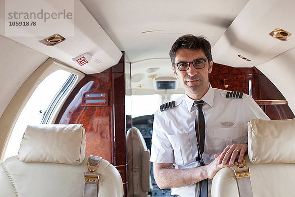 Portrait des männlichen Piloten in der Kabine des Privatjets