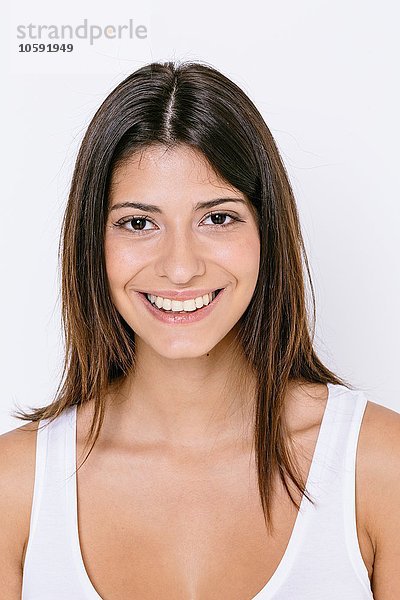 Porträt einer jungen Frau in weißer Weste mit lächelndem Blick auf die Kamera
