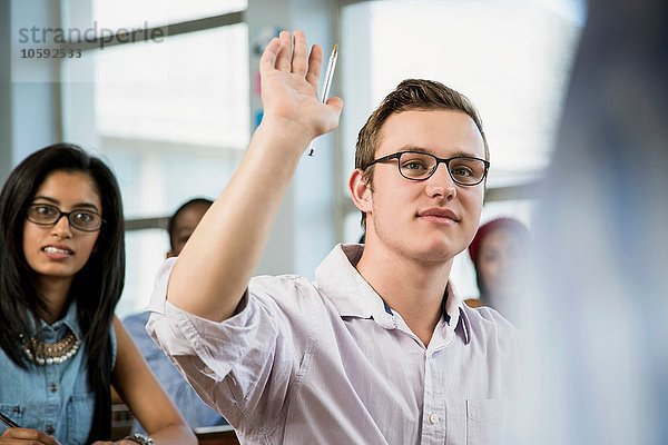 Männlicher Schüler im Klassenzimmer  handaufgezogen