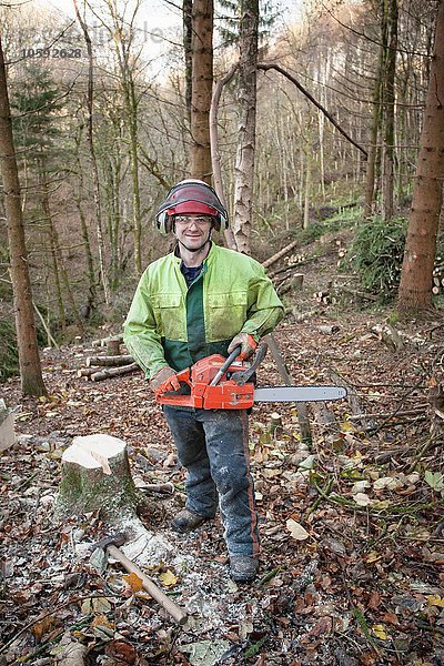Naturschützer  der in einem Naturschutzgebiet arbeitet  um nicht heimische Nadelbäume für die natürliche Wiederherstellung des Waldes zu entfernen.