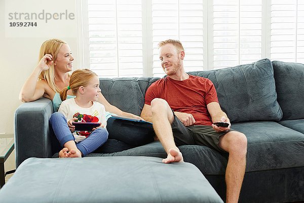 Familien-Chat und Smartphone auf dem Sofa im Wohnzimmer