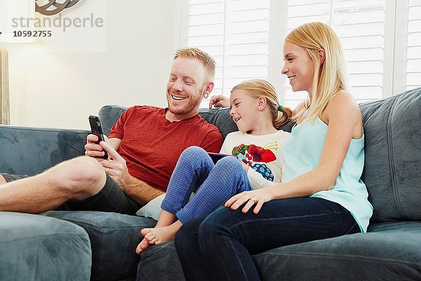 Familien-Chat und Smartphone auf dem Sofa im Wohnzimmer