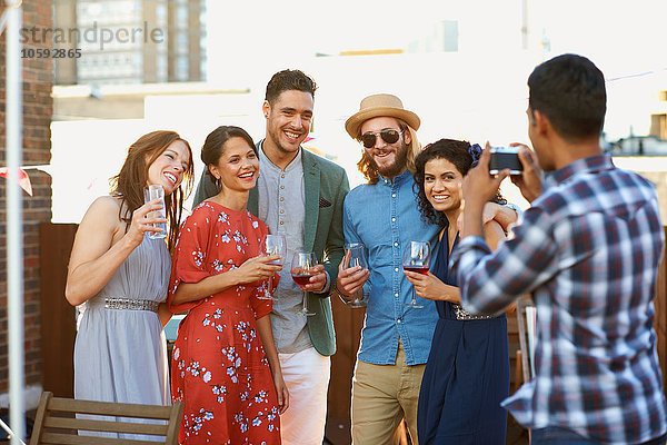 Freunde beim Fotografieren auf der Party am frühen Abend