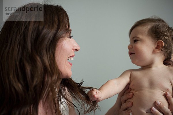 Mutter mit nacktem Brustkorb  von Angesicht zu Angesicht lächelnd