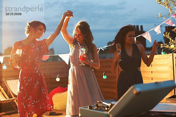 Freunde tanzen auf der Party am frühen Abend