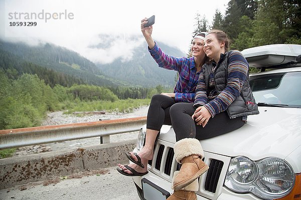 Wanderer nehmen Selfie mit Smartphone auf der Motorhaube  Lake Blanco  Washington  USA