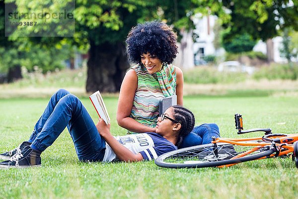 Junge und Mutter lesen und entspannen im Park