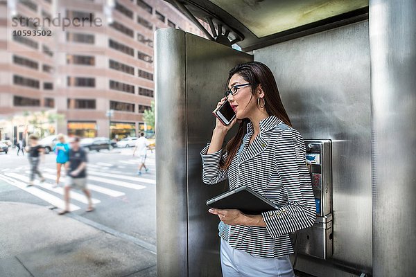 Geschäftsfrau mit Smartphone auf der Straße