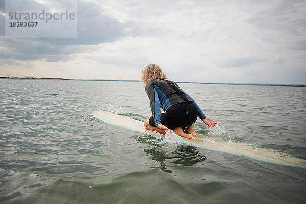 Seniorin auf dem Surfbrett im Meer  Paddleboarding