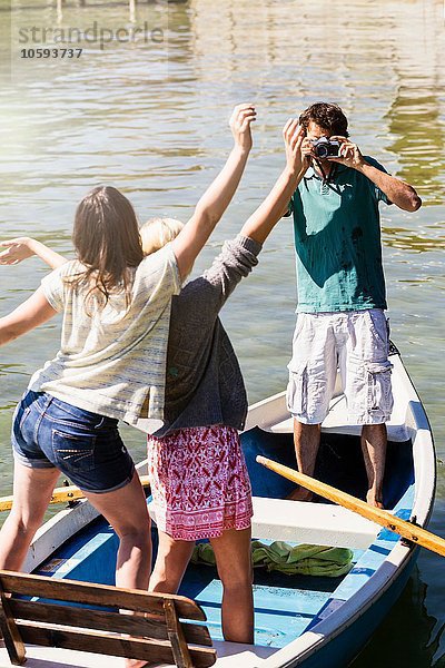 Junger Mann im Boot auf dem See fotografiert Frauen