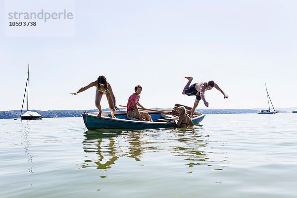 Freundeskreis taucht vom Boot in den See  Schondorf  Ammersee  Bayern  Deutschland