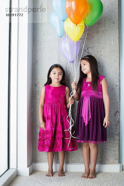 Portrait zwei junge Mädchen mit Luftballons