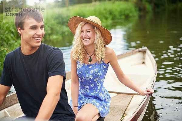 Junges Paar im Ruderboot auf dem Landfluss