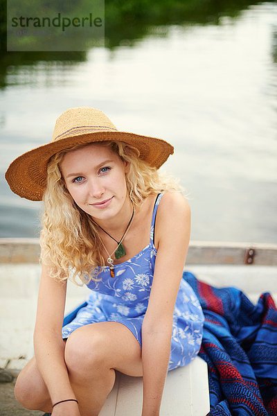 Porträt einer jungen Frau mit langen blonden Haaren im Flussboot