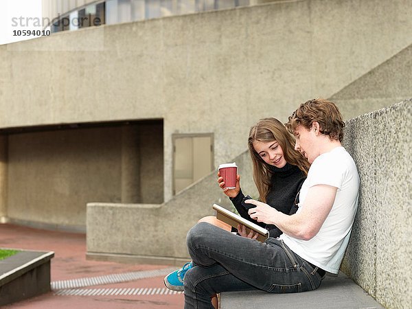Junges Paar beim Kaffee  Smartphone auf Betonbank  Melbourne  Victoria  Australien
