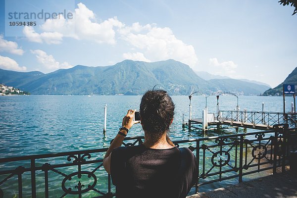 Rückansicht der mittleren erwachsenen Frau beim Fotografieren mit Smartphone  Luganer See  Schweiz