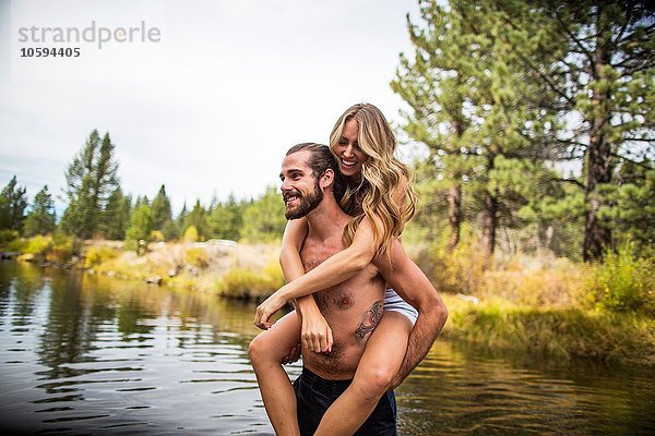 Junger Mann gibt Freundin Huckepack in River  Lake Tahoe  Nevada  USA