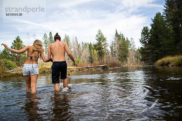 Rückansicht des jungen Paares  das den Fluss überquert  Lake Tahoe  Nevada  USA