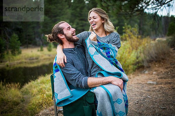 Romantisches junges Paar in Decke gehüllt am Flussufer  Lake Tahoe  Nevada  USA