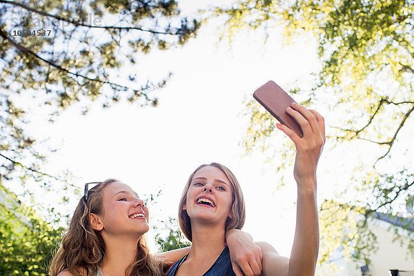 Zwei Teenager-Mädchen im Park nehmen Smartphone Selfie