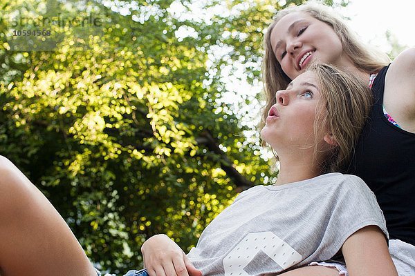 Zwei Teenager-Mädchen im Garten liegend