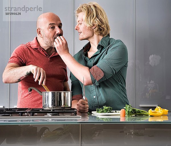 Romantisches Männerpaar beim Kochen in der Küche