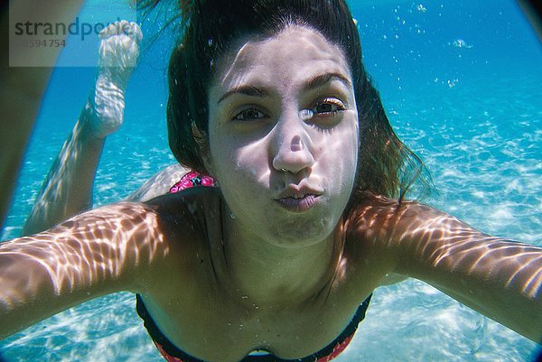 Junge Frau schwimmt unter Wasser im Meer