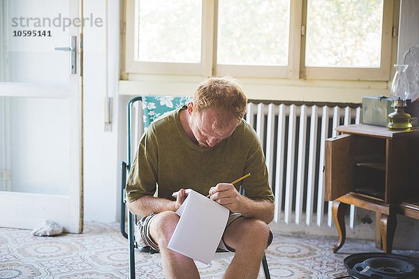 Mann schreibt Notizen im Zimmer