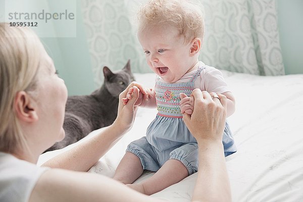 Mutter und Tochter spielen zusammen  halten Händchen.