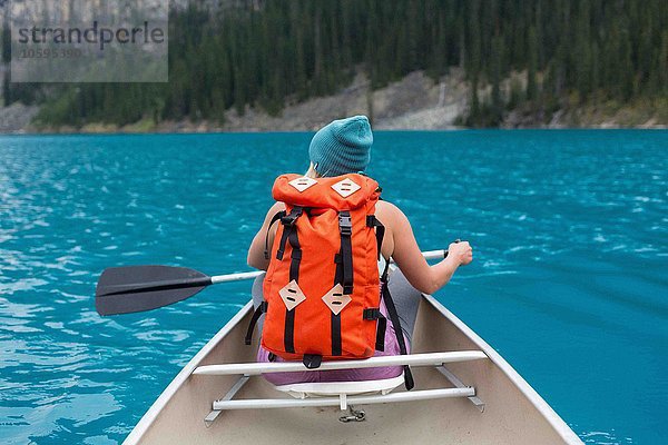 Rückansicht der mittleren erwachsenen Frau mit orangefarbenem Rucksackpaddelboot  Moraine Lake  Banff National Park  Alberta Canada