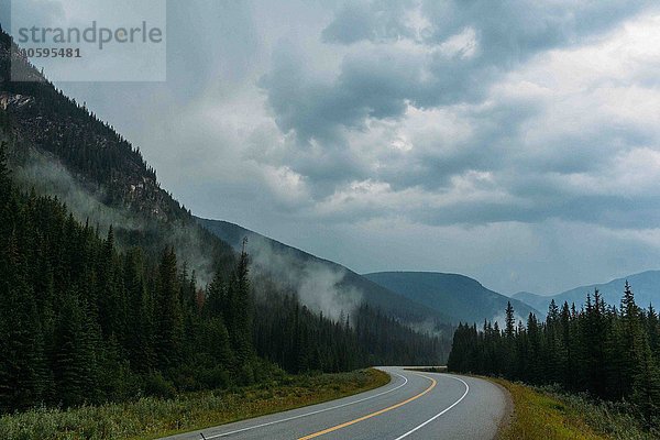 Verminderte Aussicht auf leere  offene Straßen und neblige Bergketten  Moränensee  Banff Nationalpark  Alberta Canada