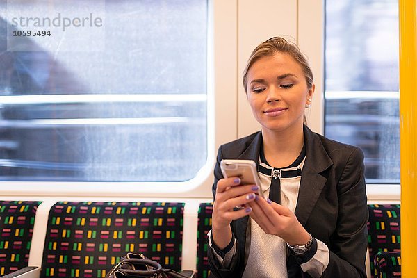 Geschäftsfrau texting on tube  London Underground  UK