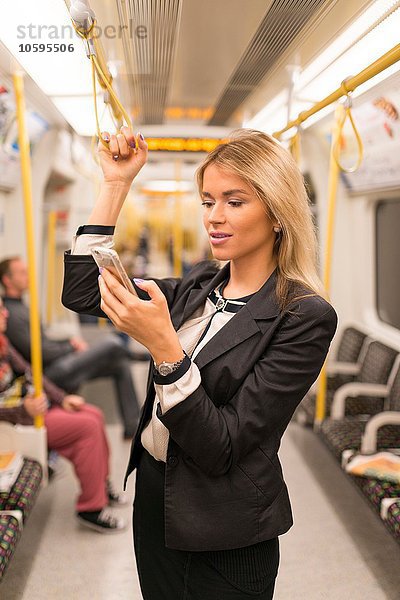 Geschäftsfrau texting on tube  London Underground  UK