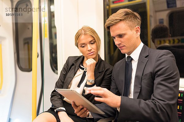 Geschäftsmann und Geschäftsfrau teilen sich ein digitales Tablett  London Underground  UK
