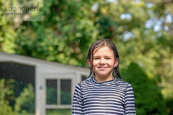 Porträt eines Mädchens im Garten  nasse Haare  lächelnd