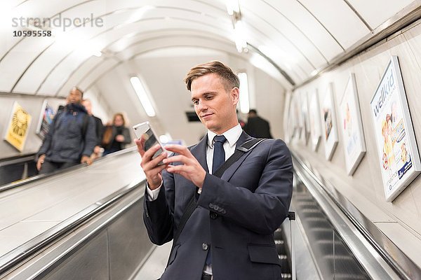 Geschäftsmann SMS auf Rolltreppe  London Underground  UK