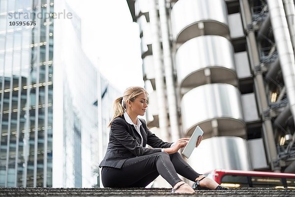 Geschäftsfrau mit digitalem Tablett in der Straße  London  UK
