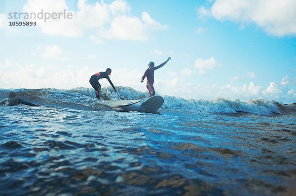 Zwei Surfer surfen im Meer