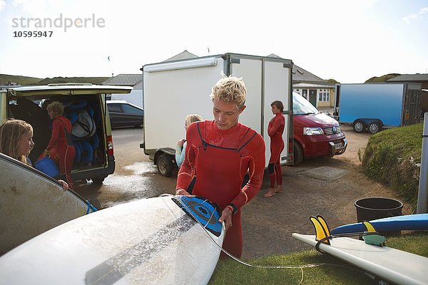 Gruppe von Surfern  die Surfbretter auswählen  sich zum Surfen vorbereiten