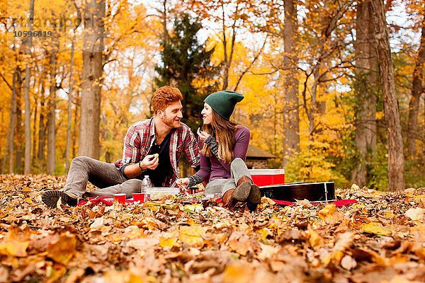 Glückliches junges Paar beim Picknick im Herbstwald