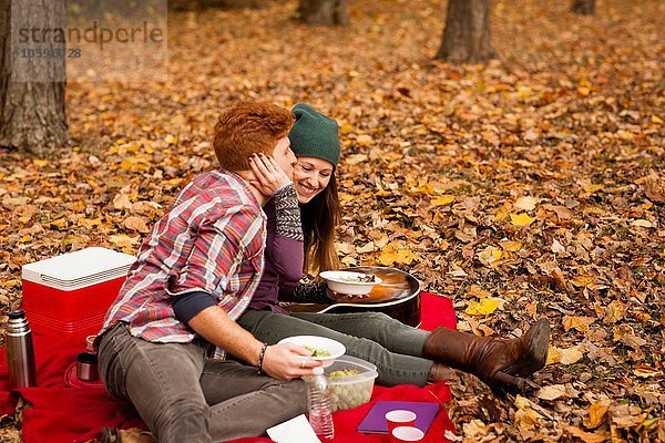Romantisches junges Paar beim Picknick im Herbstwald