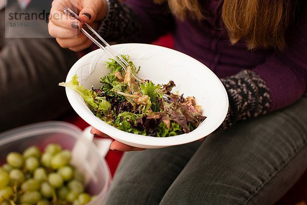 Ausschnitt eines jungen Paares  das Picknick-Salat isst.