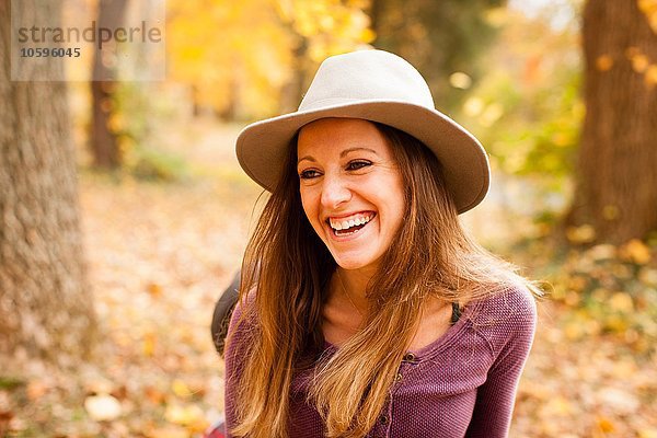 Porträt der glücklichen jungen Frau im Herbstwald