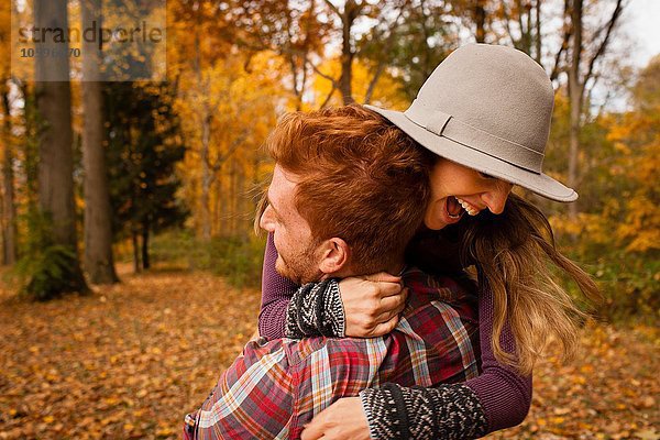 Junges Paar umarmt sich im Herbstwald