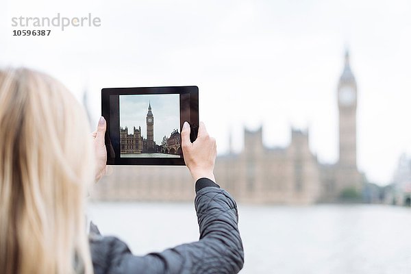 Rückansicht der jungen Frau  die Big Ben auf digitalem Tablett fotografiert  London  England  UK