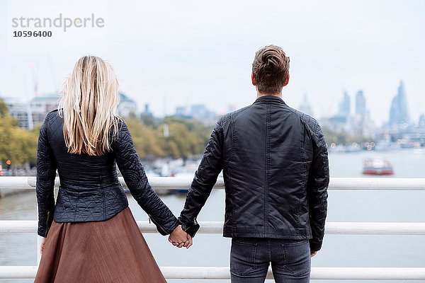 Rückansicht eines romantischen jungen Paares vor der Themse  London  England  UK