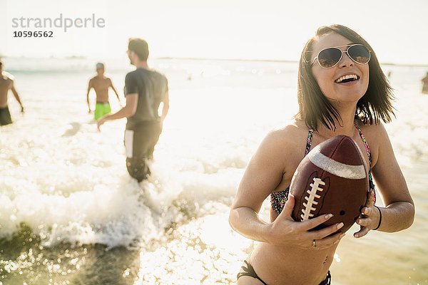 Junge Frau spielt American Football mit Freunden in Newport Beach  Kalifornien  USA