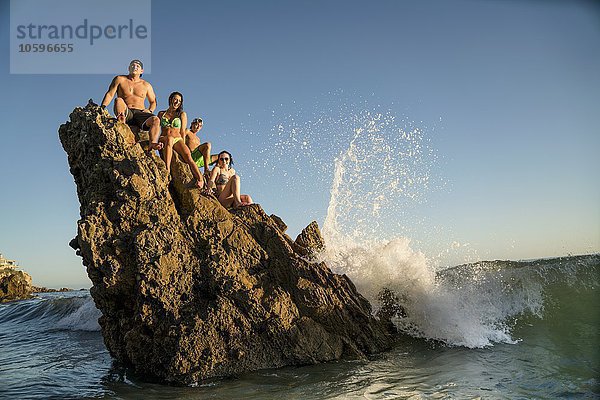 Erwachsene Freunde auf einer Felsformation in Newport Beach  Kalifornien  USA