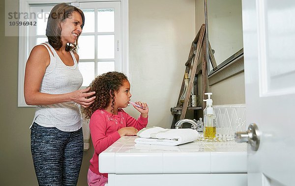 Mutter und Tochter im Bad am Waschbecken beim Zähneputzen