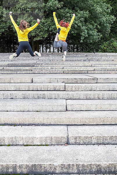 Junge Frauen springen auf Stufen